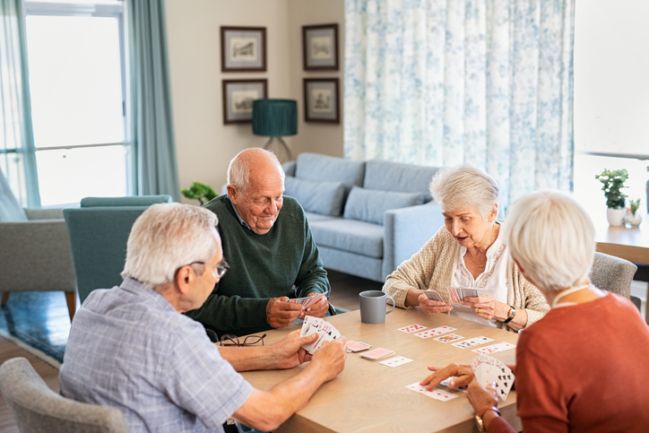 Senior friends playing cards together at nursing home